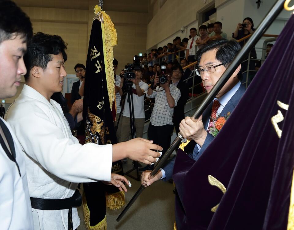 박상기 법무부장관이 전년도 우승 유도팀으로부터 우승기를 반환받고 있다.(사진=법무부)