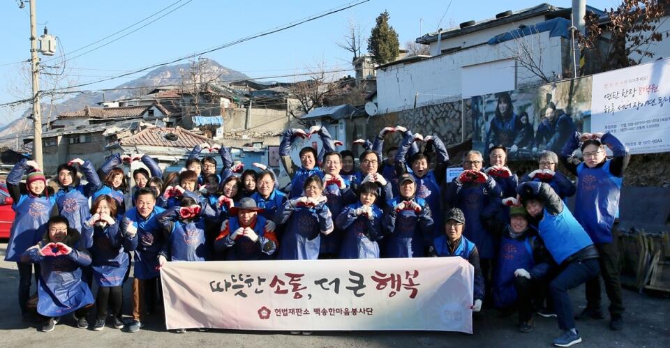 연탄 나눔 봉사활동을 하기 전 기념사진을 촬영하고 있는 김헌정 헌법재판소 사무처장과 전·현직 직원(사진=헌법재판소)