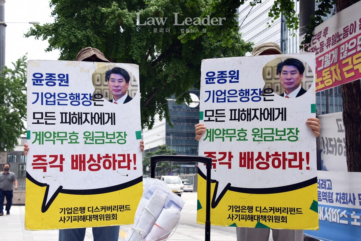 기업은행 디스커버리펀드 피해자들이 20일 기업은행 본점 앞에서 피켓 시위를 벌이고 있다.<br>