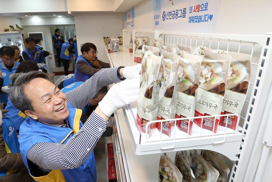 진옥동 신한금융그룹 회장이 온기창고 진열대에 후원 물품을 진열하고 있다.