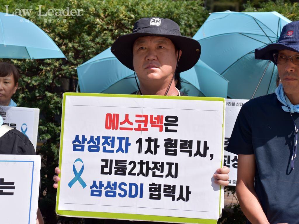 기자회견 참가자가  “ 에스코넥은 삼성전자 1차 협력사, 리튬 2차전지 삼성SDI 협력사”라고 적힌 팻말을 들고 있다.