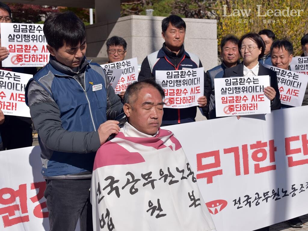 이성민 공무원노조 법원본부장이 삭발식을 하는 가운데 뒤쪽으로 양경수 민주노총 부위원장, 정혜경 진보당 국회의원, 이인섭 전 공무원노조 법원본부장이 지켜보고 있다.