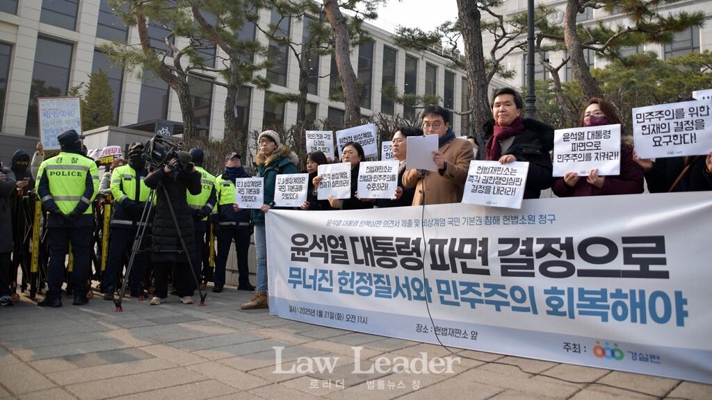 정지웅 변호사가 발언하는 도중에도 경찰 저지선 너머로 윤석열 대통령 지지자들이 고성을 외치고 있다.