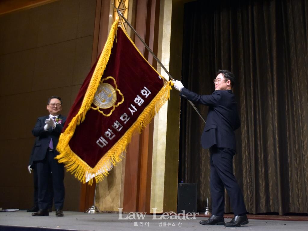 김정욱 신임 대한변협회장이 협회기를 펼쳐보이고 있다.