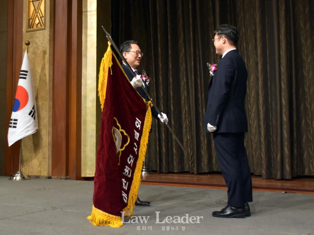 김영훈 제52대 대한변협회장이 김정욱 신임 제53대 대한변협회장에게 협회기를 전달하고 있다.