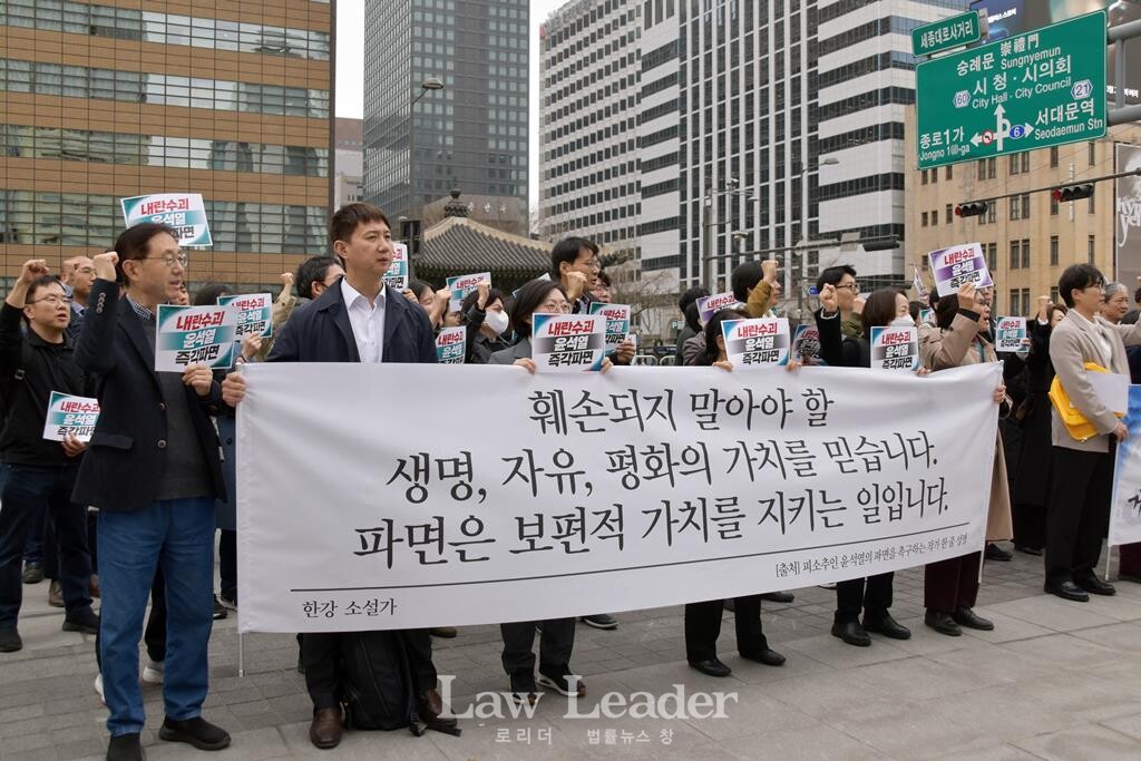 민변 회원 변호사들이 한강 작가의 발언을 인용한 현수막을 들고 구호를 외치고 있다.