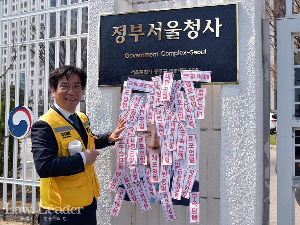 김남주 민변 민생경제위원장(변호사)이 한덕수 국무총리의 팻말 앞에서 손을 흔들고 있다.