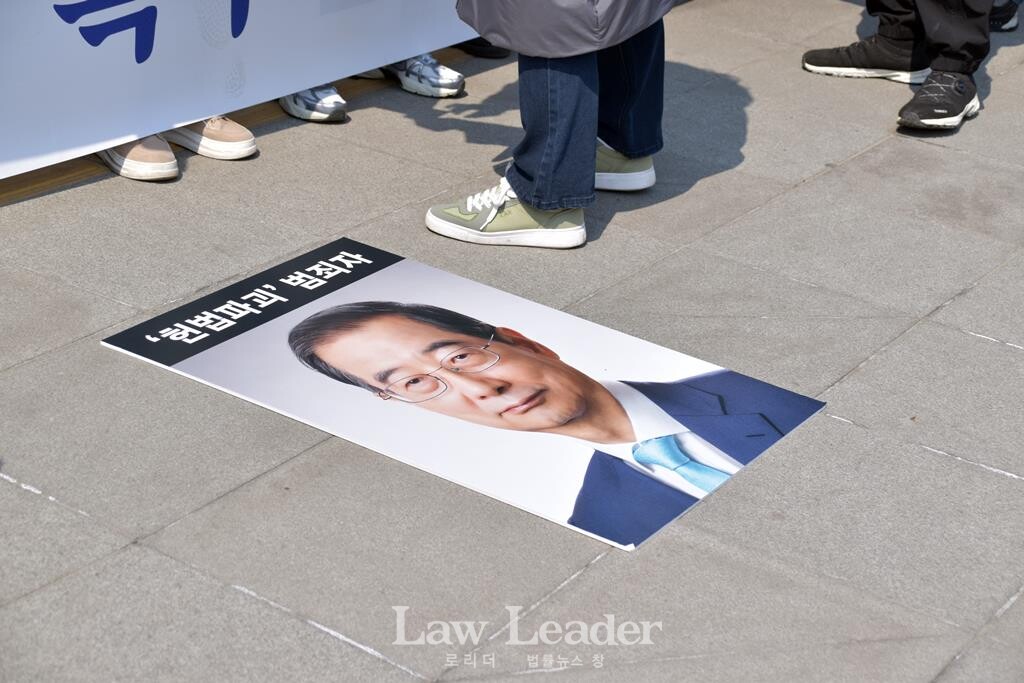 한덕수 대통령 권한대행의 사진이 퍼포먼스 시작 전 바닥에 놓여있다.