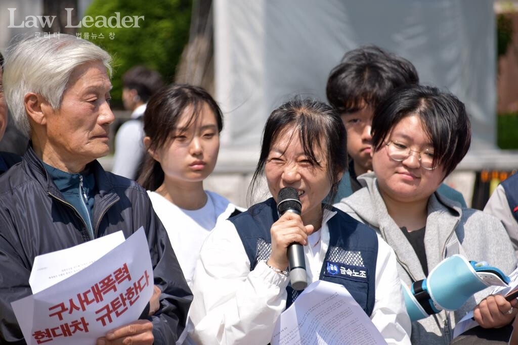 이수기업 해고 당사자인 금속노조 현대자동차비정규직지회 안미숙 조합원이 기자회견 참가자들로부터 응원을 받아 미소를 짓고 있다.