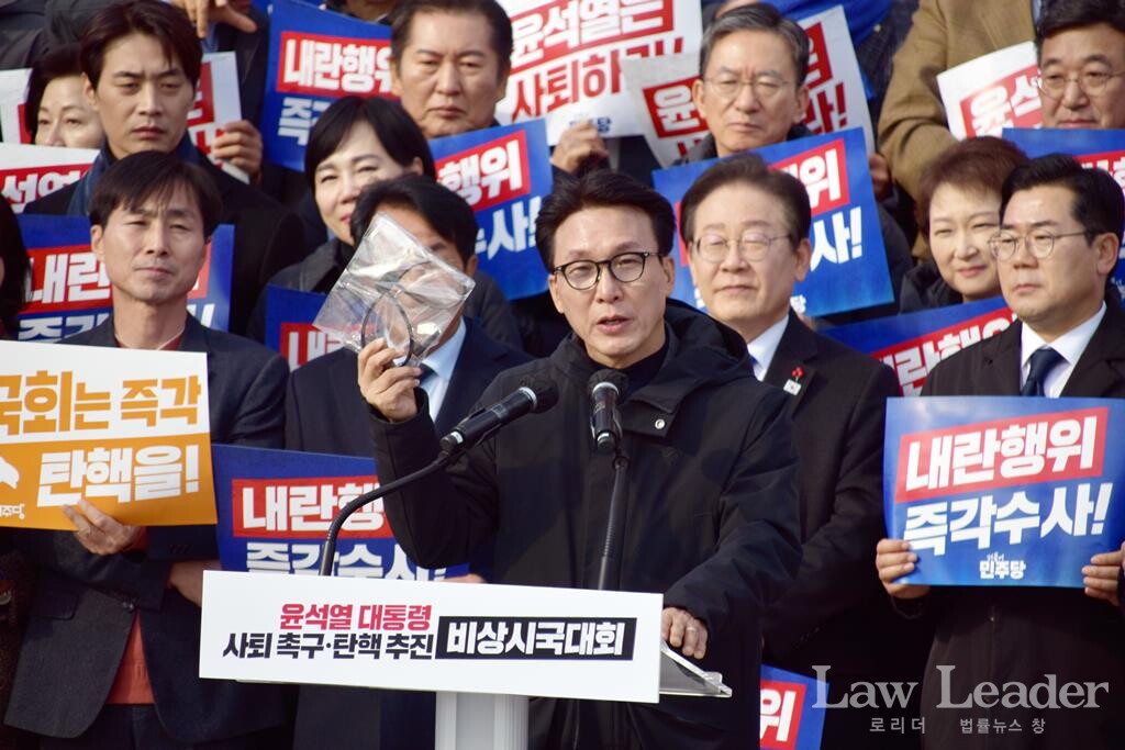 8월부터 계엄을 경고했던 김민석 더불어민주당 수석최고위원이 계엄군이 떨어뜨린 수갑을 들고 발언하고 있다.