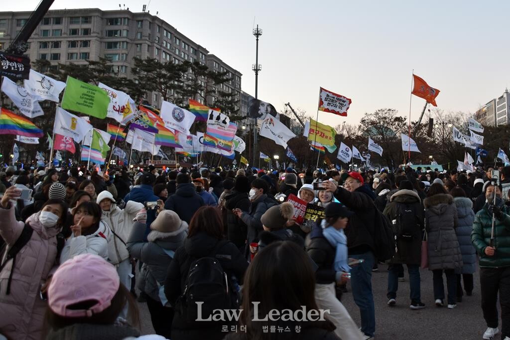 12월 14일, 윤석열 대통령에 대한 국회의 탄핵소추안이 가결되자 집회에 참여한 시민들이 기념사진을 촬영하며 환호하고 있다.