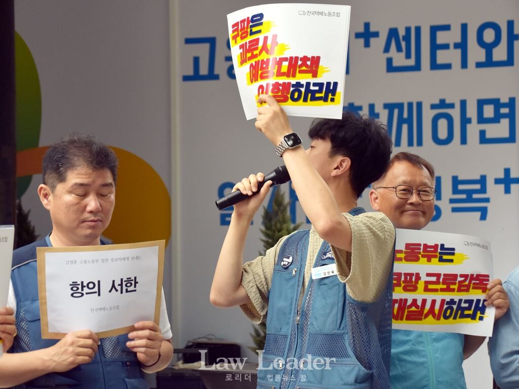 강민욱 택배노조 쿠팡본부 준비위원장이 서울지방고용노동부가 있는 건물을 가리키며 발언하고 있다.