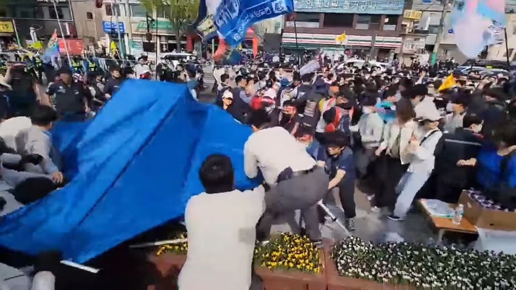 베이지 색 옷을 입은 현대차 구사대가 이수기업 해고노동자 및 연대시민들이 설치하려는 천막을 탈취하려는 장면(사진=유튜브 채널 “이수기업해고자” 영상 캡처)